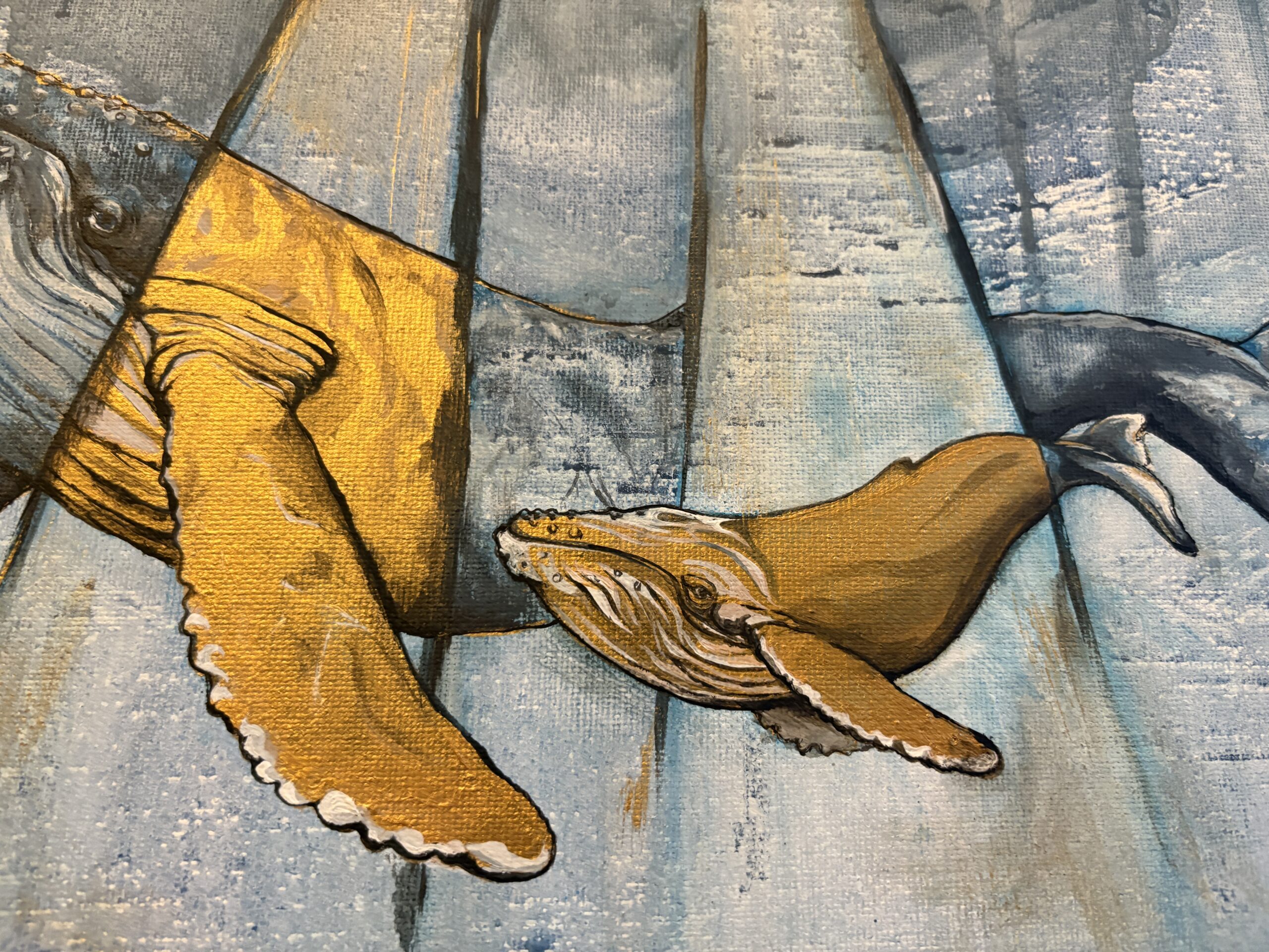 Close-up of a humpback whale calf in black and gold within the painting